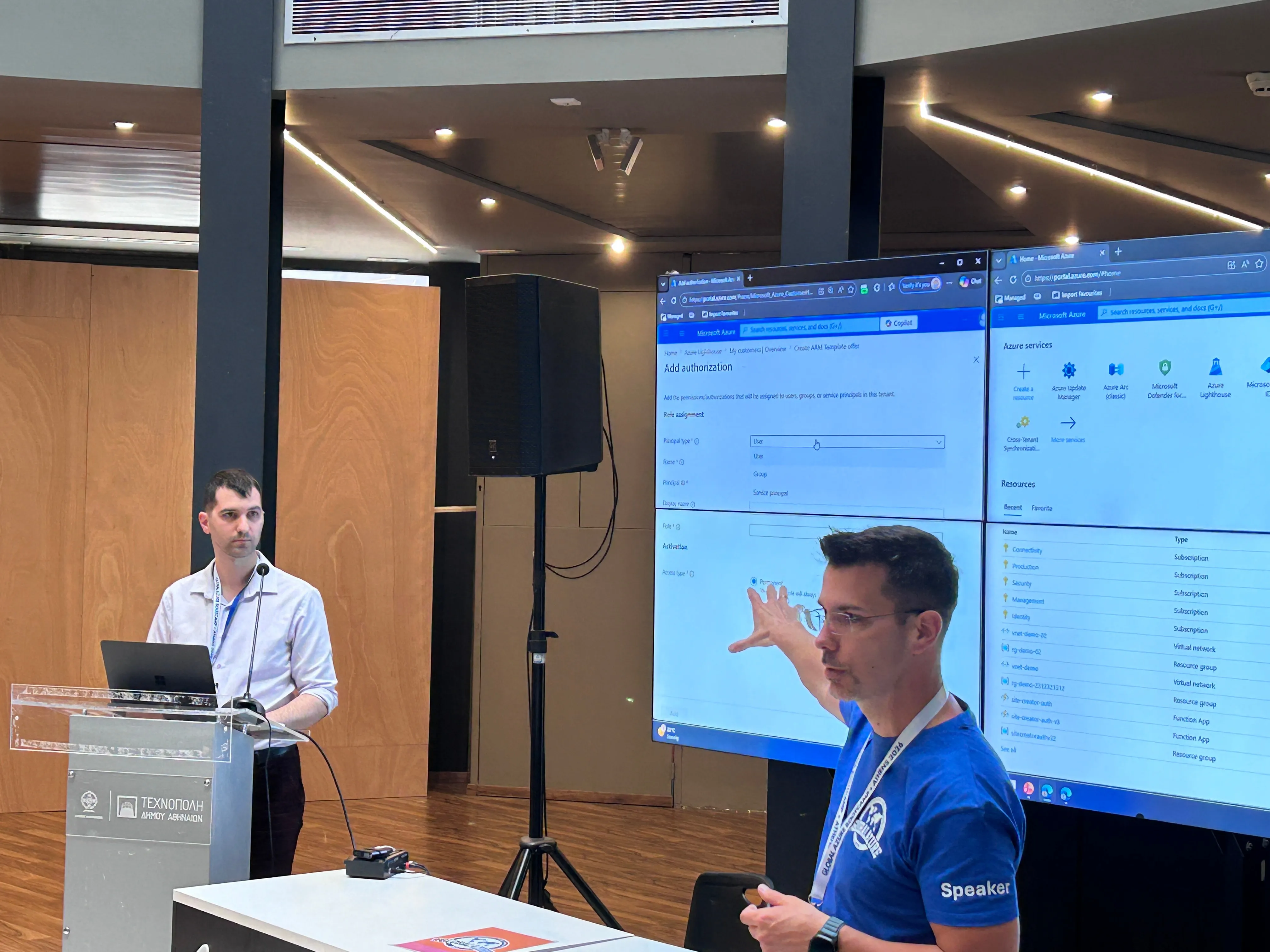 Spiros Karampinis erklärt bei Global Azure Athens eine Azure-Lösung, begleitet von Stamatis Valsamidis am Projektor.