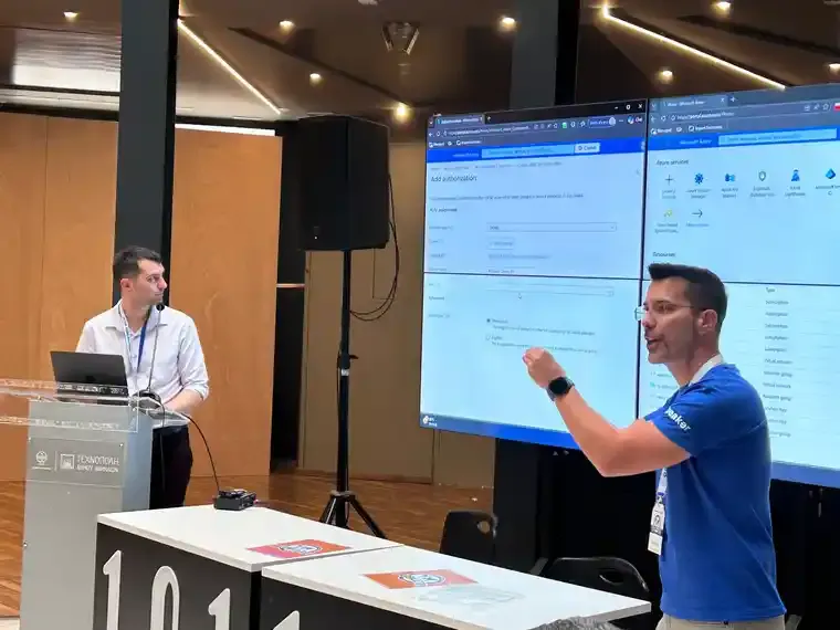Zwei Kollegen von Cloud Dream Team bei einer Microsoft-Azure-Session, einer am Laptop und einer vor den Azure-Bildschirmen.
